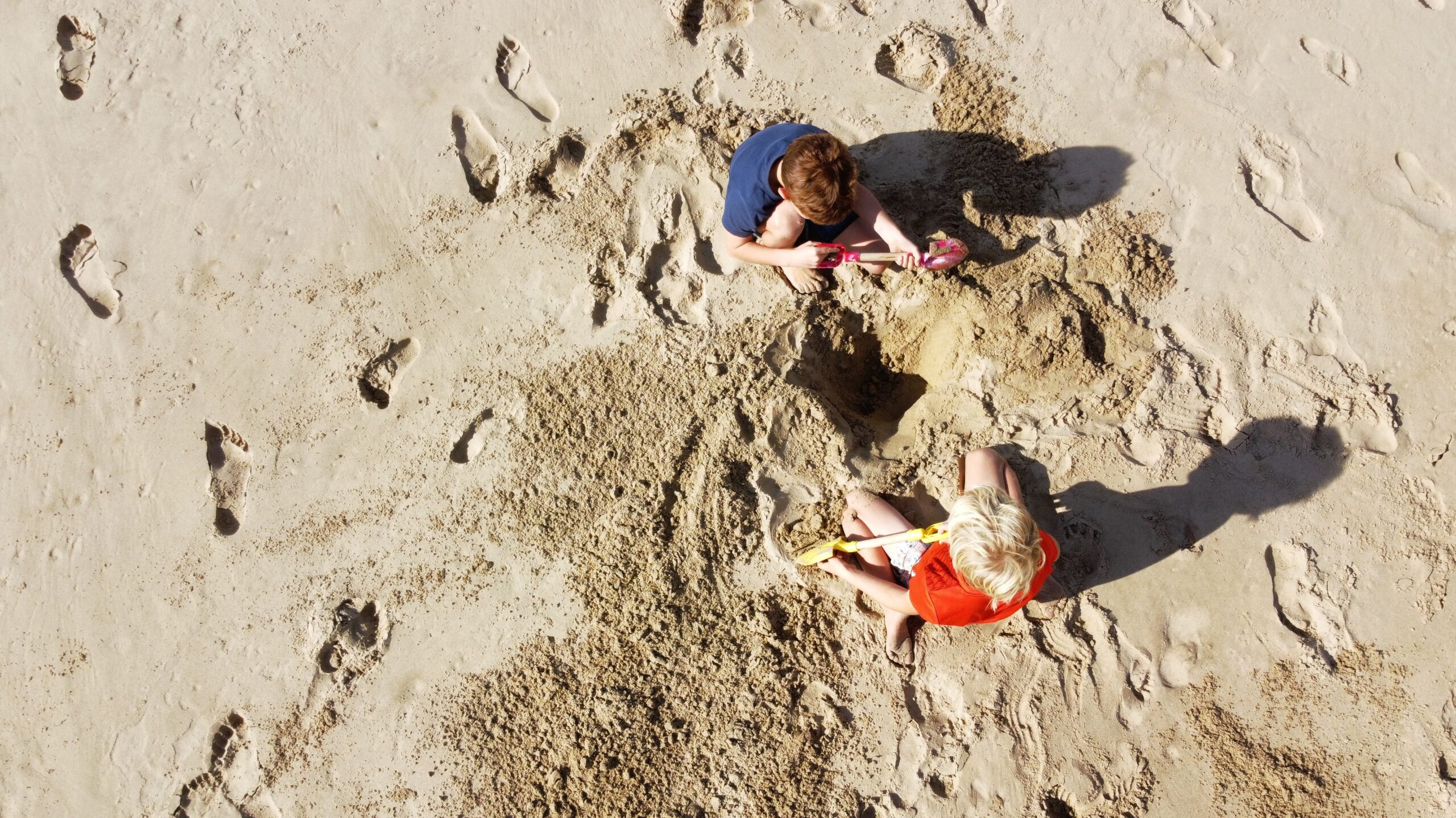 kids building sand castle on beach