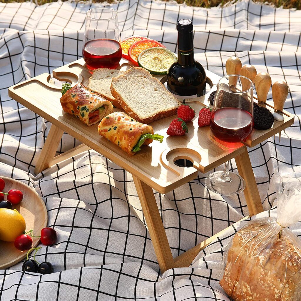 bamboo beach table with wine and cheese on it